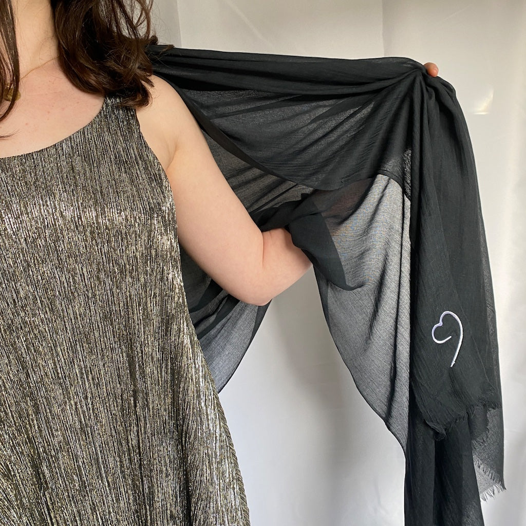 Muze black lightweight scarf in modal and silk on model displaying fineness of fabric and embroidery of a original artistic heart drawing