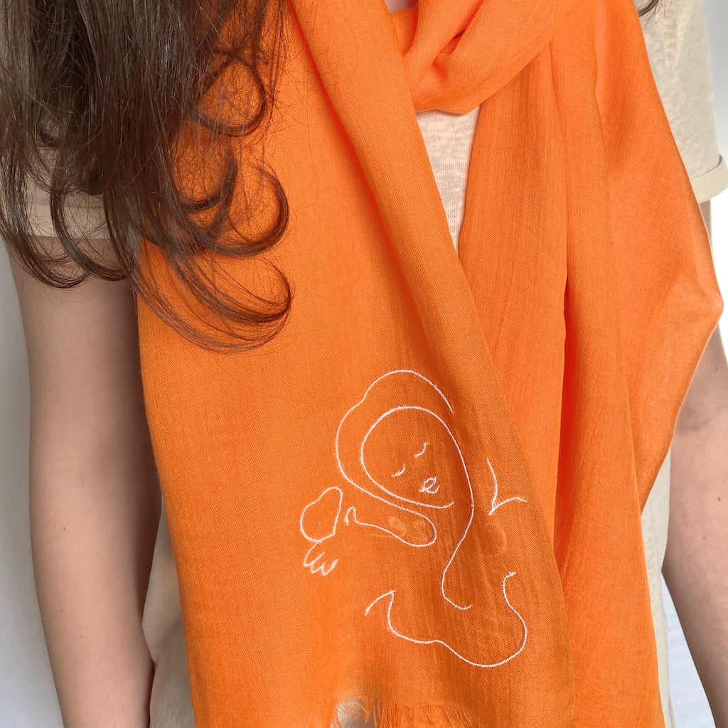 Muze orange lightweight scarf in modal and silk on model displaying embroidery of muze love heart original artistic drawing