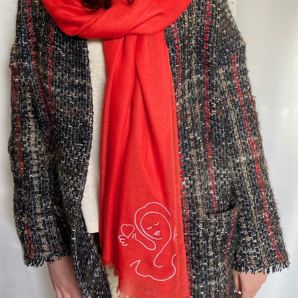 Muze red lightweight scarf in modal and silk on model displaying embroidery of muze love original artistic drawing on one side