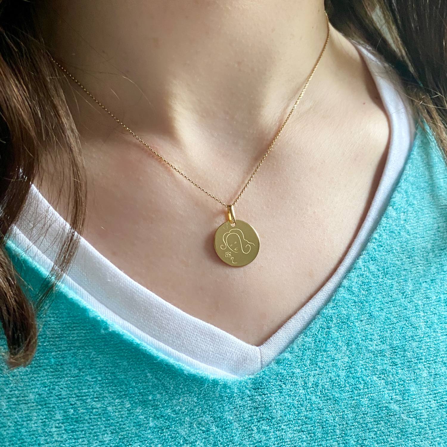 Muze 18k gold vermeil Faith medal necklace on model with blue top,  art inspired jewelry, dainty talisman symbol of hope, protection and spirituality. A sentimental gift perfect for newly born, godchild or as a friendship thank you gift.